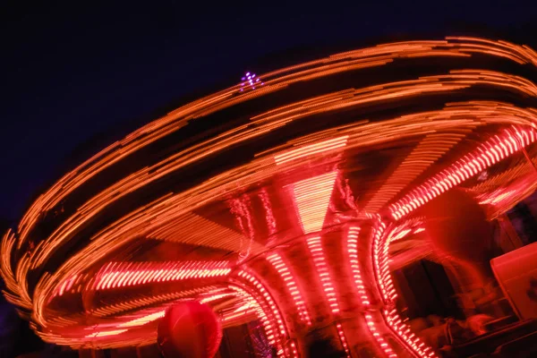 夜の遊園地で美しい明るいカルーセルをモーションします — ストック写真