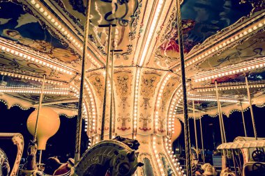 Çocuk Carousel, akşam ve gece aydınlatma bir eğlence parkında. gece eğlence parkı. Açık vintage renkli atlıkarınca içinde şehir. Vintage fotoğraf işleme