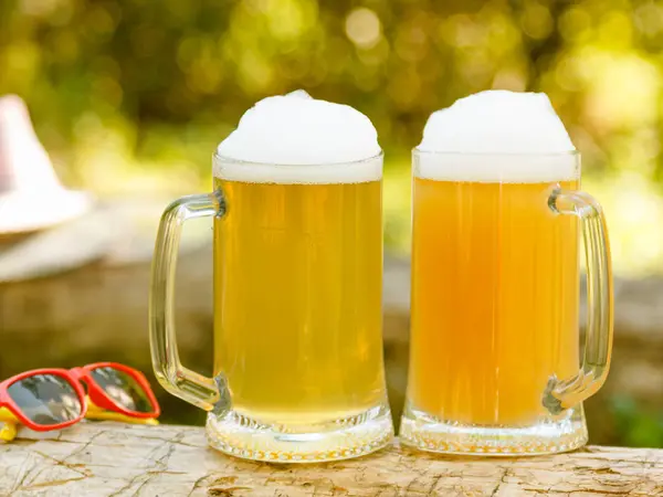 Dos Cervezas Con Espuma Taza Sobre Fondo Verde Aire Libre —  Fotos de Stock