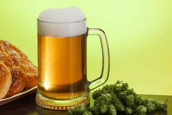 一品脱啤酒配料为自制啤酒在黄色背景与椒盐脆饼 — 图库照片