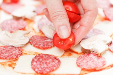 Domates mozzarella ve salam üzerinde bir ham pizza yakın çekim koyarak Cook