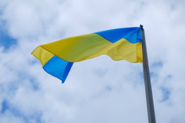 Ukrayna bayrağı mavi gökyüzü bulutlu karşı uçar.