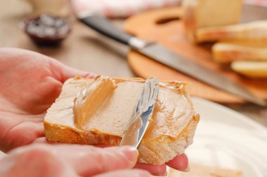 Fıstık ezmesi sandviç yemek. Kesme tahtası, bıçak ve el.