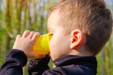 küçük çocuk zammı bir plastik bardaktan içer. Açık.