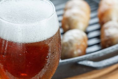 Kızarmış sosis, bira ile Pan. Ahşap arka plan