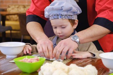 Yemek, geleneksel sushi hazırlanması alır. Çocuk aşçı olarak giyinmiş.
