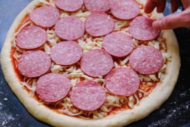 Taze İtalyan çiğ pizzası, geleneksel usulde fırında pişirme tepsisi üzerinde hazırlanma.