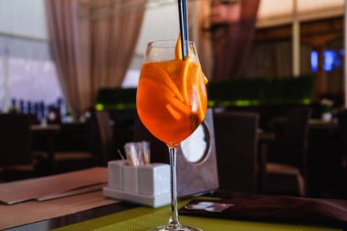 Lokantanın iç kısmında, masasında ve sandalyelerinde kokteyl bardağı var.