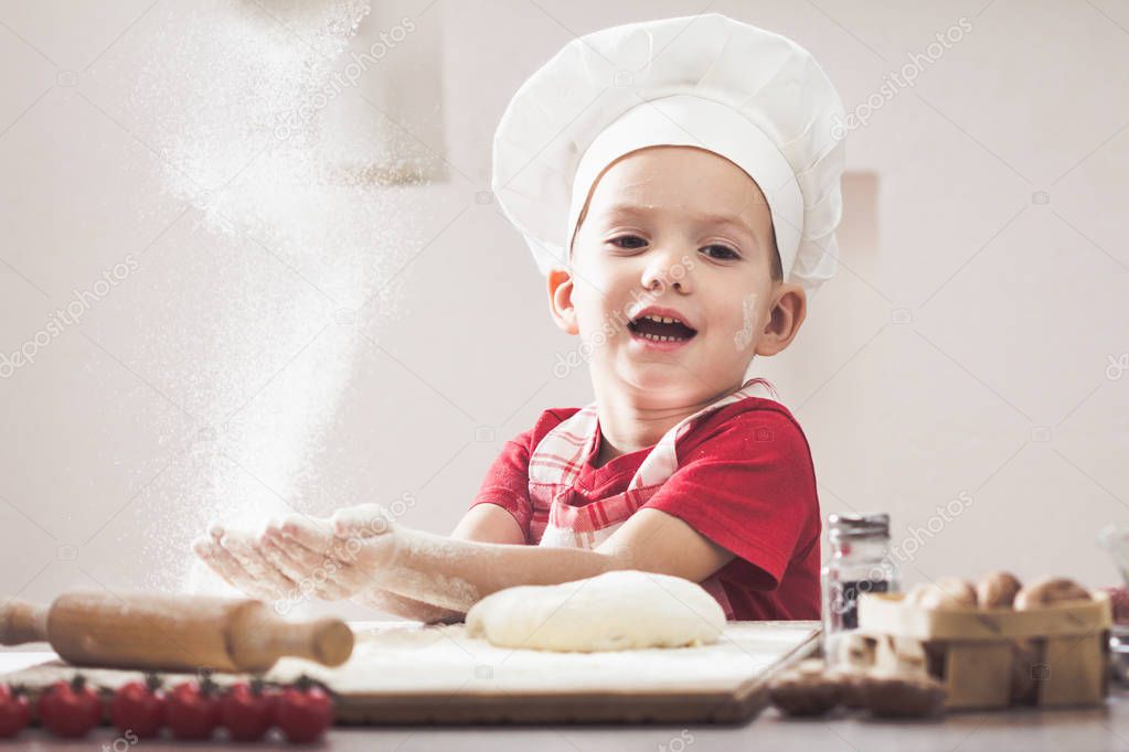 Making the dough for pizza is fun - little chef playing with flour