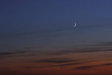 Günbatımı ve ay kırmızı arka plan. Karşı bulutlar. Güzel gökyüzü, pembe bulutlar. Günbatımı ve new moon dua zamanı