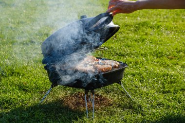 Smokehouse doğada yaz bahçesinde ızgara üzerinde duruyor. Balık evde aileniz için sigara.