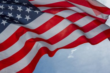 Rüzgar star elimden Amerikan bayrağı mavi gökyüzüne karşı sallayarak.