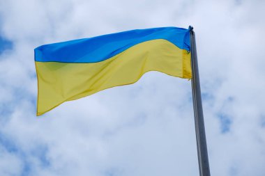 Ukrayna bayrağı mavi gökyüzü bulutlu karşı uçar.