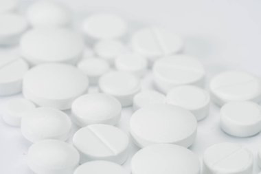 Tıbbi soyut kavram. Beyaz arka plan makrosu üzerinde izole beyaz haplar ve tabletler