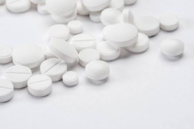 Beyaz arka plan makrosu üzerinde izole edilmiş, kopyalama alanı olan beyaz haplar ve tabletler