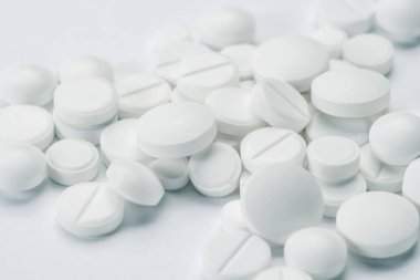Tıbbi soyut kavram. Beyaz arka plan makrosu üzerinde izole beyaz haplar ve tabletler