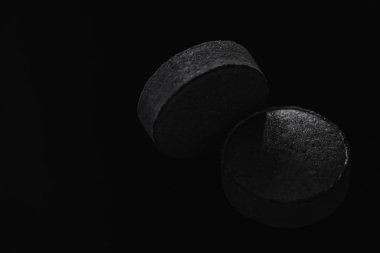 Siyah arka plan üzerinde aşırı yakın çekim makro izole siyah hapı tablet ilaç yalan..