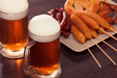 Yiyecek sosis, ızgara kraker ile bira cam alkollü içecek.