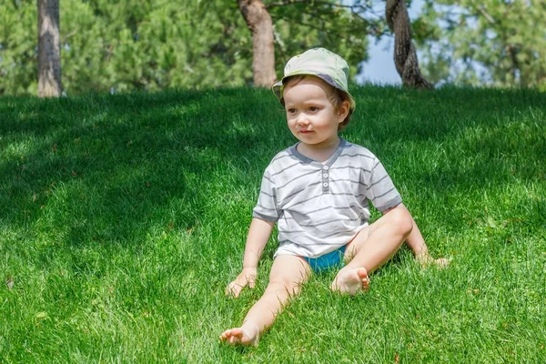 Niño en césped de hierba verde en el parque de verano, lindo . —  Fotos de Stock