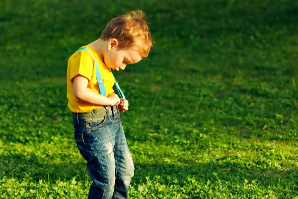 Jongen op groene gras gazon in zomerpark, Kid. — Stockfoto