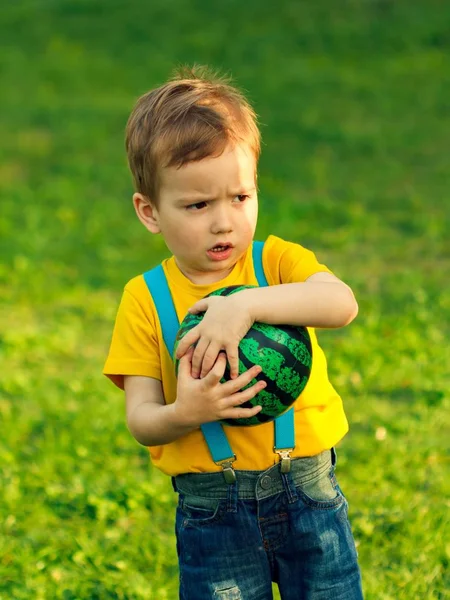 Menino no gramado de grama verde no parque de verão, ao ar livre . — Fotografia de Stock