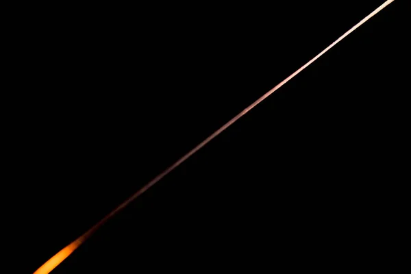 Вузький промінь світла на лезі сталевого ножа на чорному абстрактному фоні — стокове фото