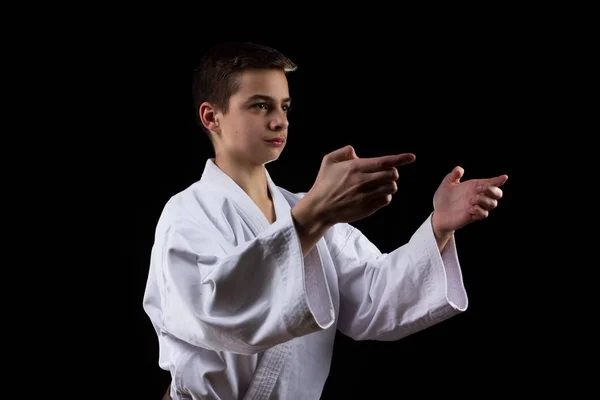 Karate deporte marcial con chico joven en kimono, fondo negro, personas . — Foto de Stock