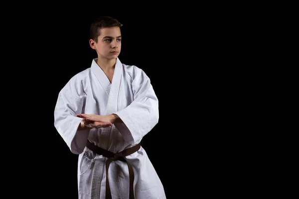 Karate deporte marcial con chico joven en kimono, fondo negro, persona . — Foto de Stock