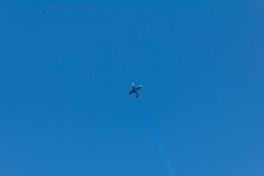 Mavi gökyüzünde bir uçağın arkasında batan güneşin tarafından vurgulanan yoğunlaşma izleme. Yoğunlaşma izlemek eski inversiyon iz