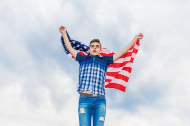 ABD bayrağı bir yaz gökyüzü arka planda çalışan bir adam tarafından düzenlenmektedir