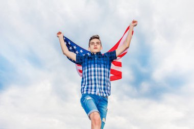 ABD bayrağı bir yaz gökyüzü arka planda çalışan bir adam tarafından düzenlenmektedir