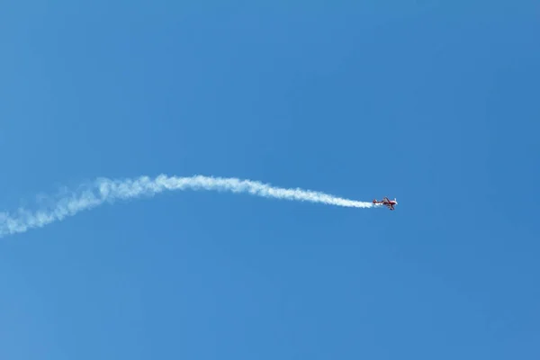 Huella de condensación resaltada por el sol poniente detrás de un avión en el cielo azul. Rastreo de condensación el sendero de inversión obsoleto — Foto de Stock