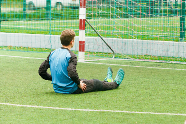 Goalkeeper and goal at the football field, warms up before soccer game