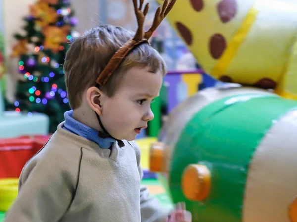 Menino se divertindo no parque de diversões para crianças e no centro de jogos indoor. Criança brincando com brinquedos coloridos no playground . — Fotografia de Stock