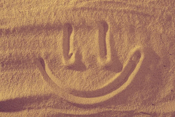 Handwrited face on the sand at the beach. Symbol smile on beach background. — Stock Photo, Image