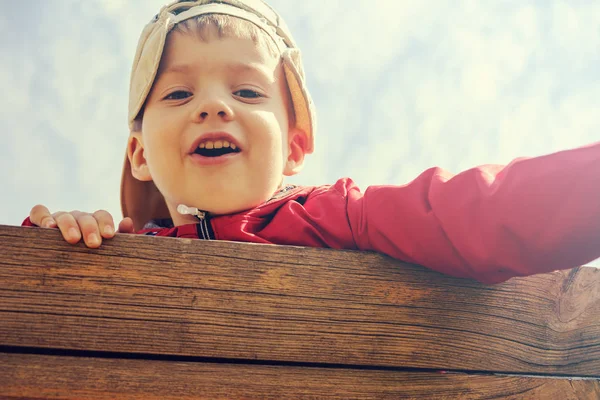 Kaukasische jongen gelukkig met Cap op blauwe hemel — Stockfoto