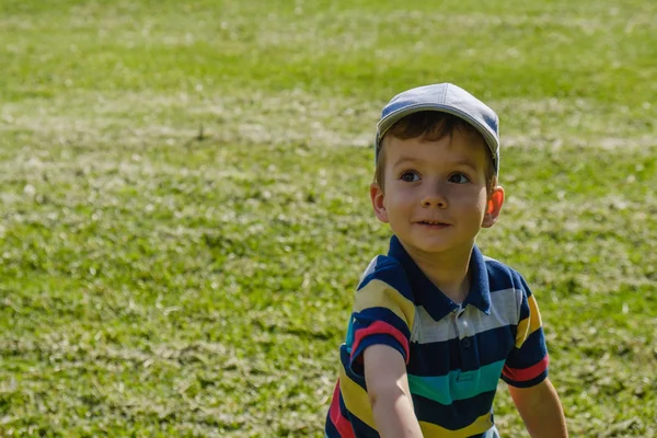 Jongen speelt met een vliegtuig speelgoed in het park op een zonnige dag — Stockfoto