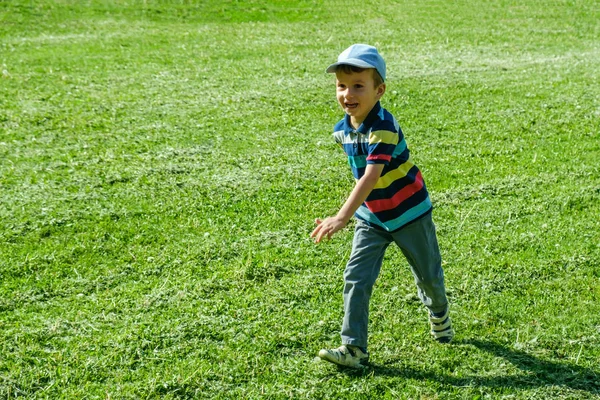 Menino brincando com um avião de brinquedo no parque em um dia ensolarado — Fotografia de Stock