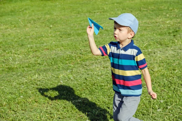 晴れた日に公園で青いおもちゃの飛行機で遊んでいる少年 — ストック写真
