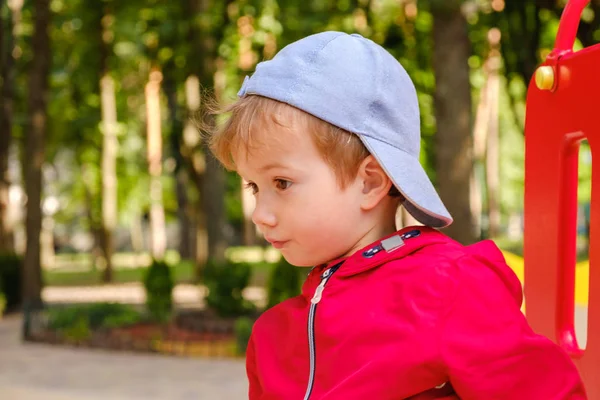 Pojke spelar på lekplats karusell i parken — Stockfoto