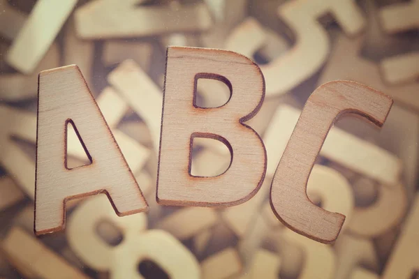 Letras del alfabeto establecen símbolos sobre fondo de madera —  Fotos de Stock