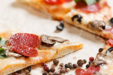 Erimiş peynirli sıcak pizza dilimi, mantarlı, salamlı, peperonili, domatesli, fesleğenli.