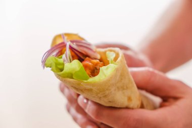 Meksika dürümü, tavuk, sebze, biber ve fasulye. Burrithos elinde yemek tutuyor. Beyaz arka planda sokak yemekleri