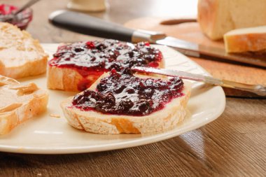 Reçelli fıstık ezmeli sandviç. Kesme tahtası, mutfak bıçağı..