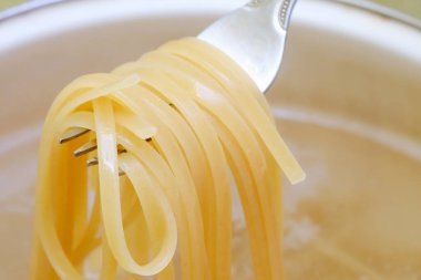 Tavada spagetti kaynayan suda pişiyor, makarna pişiriyor, şehriye pişiriyor.