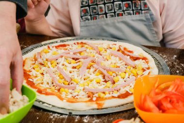 Ahşap arka planda taze malzemeli çiğ pizza pişirmek..