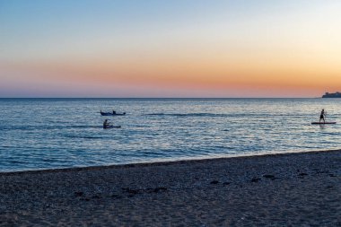 Deniz manzaralı gün batımı tekneler ve kanolarda yürüyor..