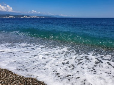 Dağların manzaralı çakıl taşı plajında mavi deniz manzaralı deniz manzarası .