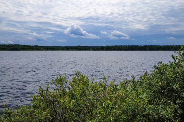 Gölün üzerindeki yaz manzarası Bulutlu mavi gökyüzü