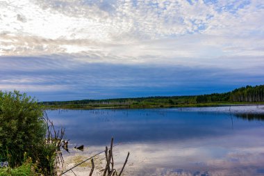 Yağmurdan önceki yaz manzarası Göldeki suda bir yansımayla.